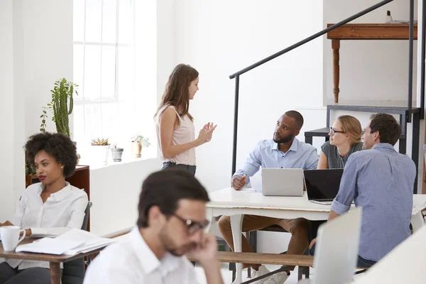 Colleagues in discussion around desk — Stock Photo, Image