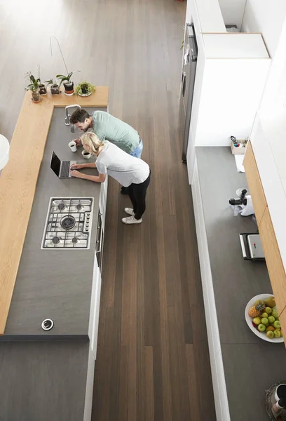 Modern mutfak içinde Laptop bakarak çift havai görünümü — Stok fotoğraf
