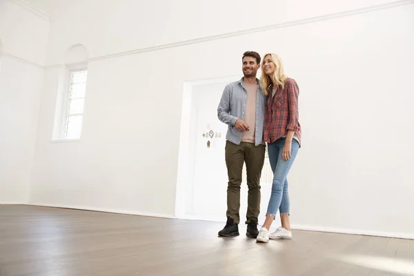 Casal jovem em pé na nova casa — Fotografia de Stock