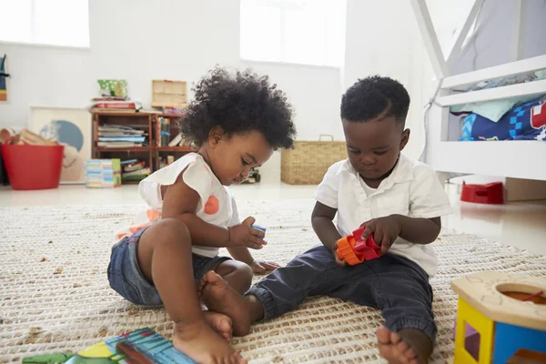 Niño y niña jugando con juguetes —  Fotos de Stock