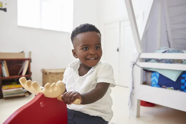 Ragazzo seduto sul giocattolo in sala giochi — Foto Stock