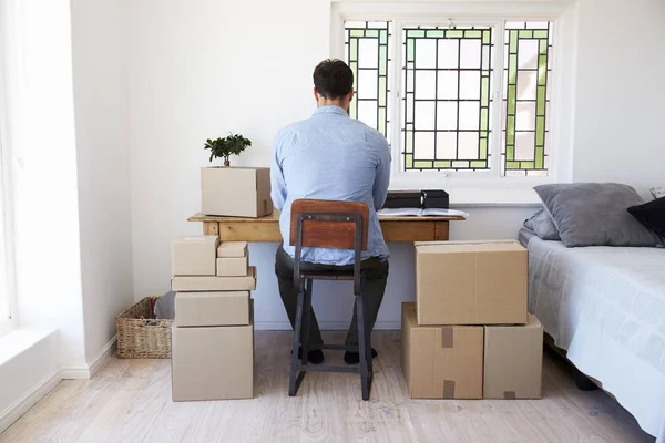 Hombre sentado en la mesa con cajas — Foto de Stock