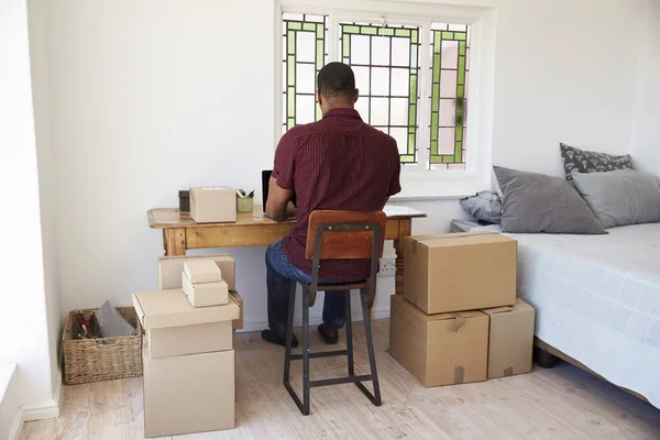 Kutuları ve dizüstü bilgisayar ile masada oturan adam — Stok fotoğraf