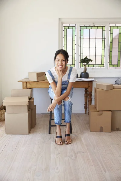 Woman sitting at table with boxes — Stock Photo, Image