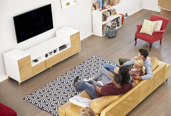 Amici seduti sul divano e guardando la televisione — Foto Stock