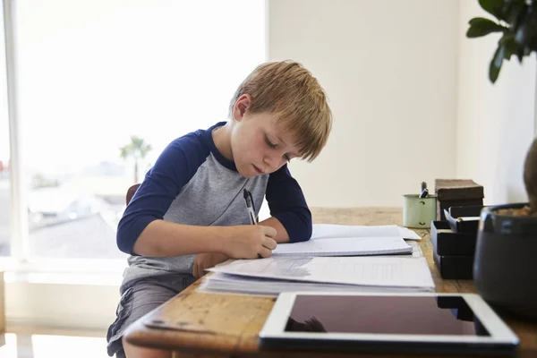 Garçon faire des devoirs à table — Photo