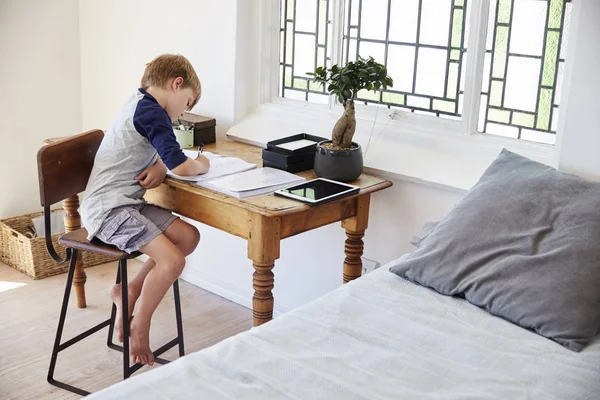 Garçon faire des devoirs à table — Photo