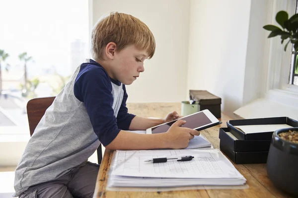 Мальчик с цифровым планшетом за столом — стоковое фото