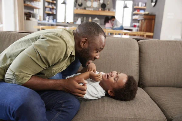 Vader en zoon spelen op sofa — Stockfoto