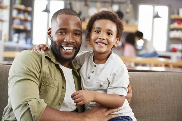 Padre e hijo sentados en el sofá — Foto de Stock