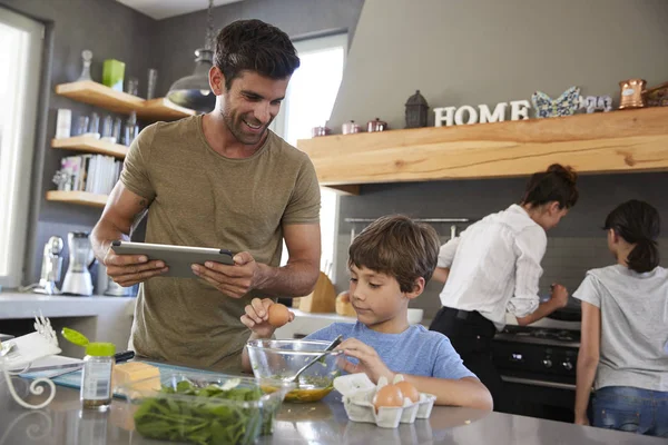 Família na cozinha seguinte receita — Fotografia de Stock