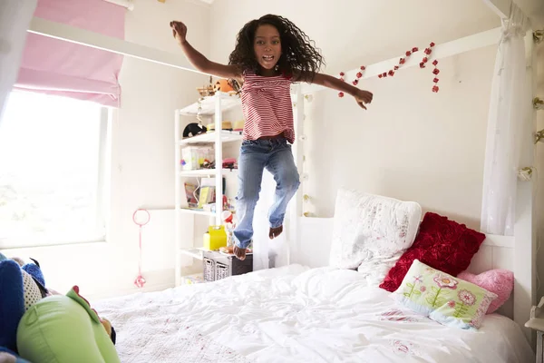 Jong meisje springen op bed — Stockfoto