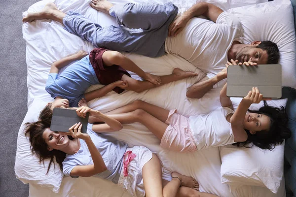Οικογένεια στο κρεβάτι χρησιμοποιώντας ψηφιακές ταμπλέτες — Φωτογραφία Αρχείου
