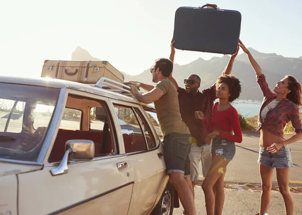 Przyjaciele załadunek bagażu na dachu samochodu — Zdjęcie stockowe