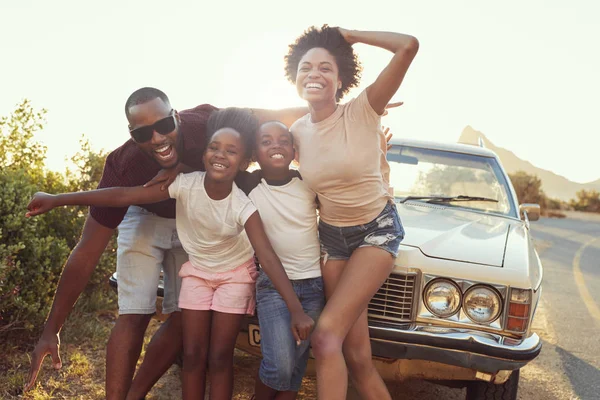 Family posing near retro clssic car