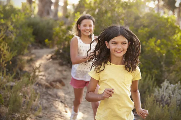 Twee jonge meisjes lopen te glimlachen — Stockfoto