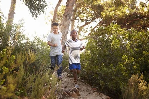 Due giovani ragazzi sorridenti che corrono — Foto Stock