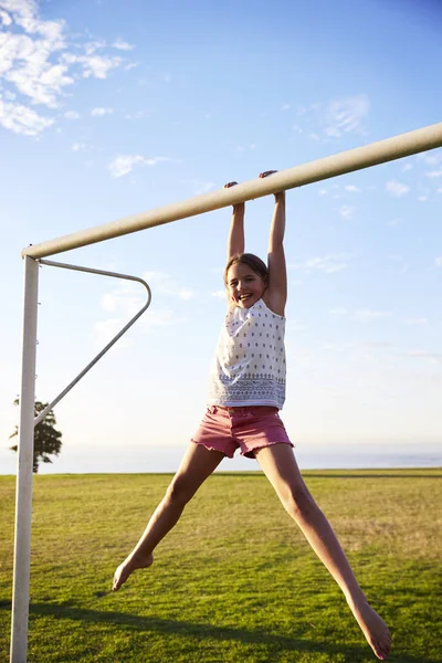 Flicka hängande från mål post — Stockfoto