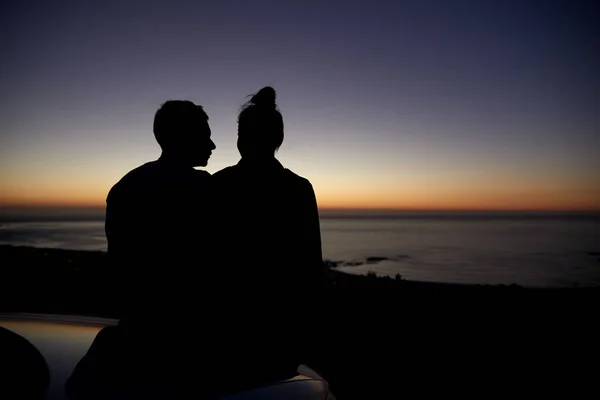 Paar entspannt sich bei Sonnenuntergang am Meer — Stockfoto