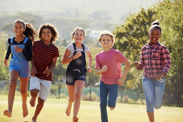 Amigos pre-adolescentes corriendo en el parque —  Fotos de Stock