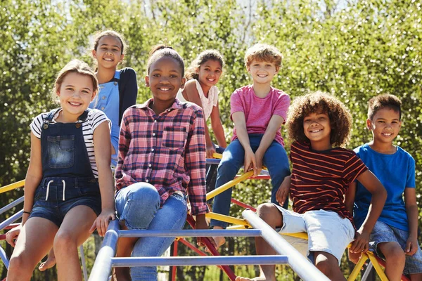 Freunde sitzen auf Klettergerüst — Stockfoto