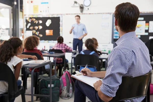 Profesor en prácticas escribiendo en el escritorio de la escuela — Foto de Stock