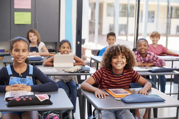 Школярі початкової школи сидять за столами — стокове фото