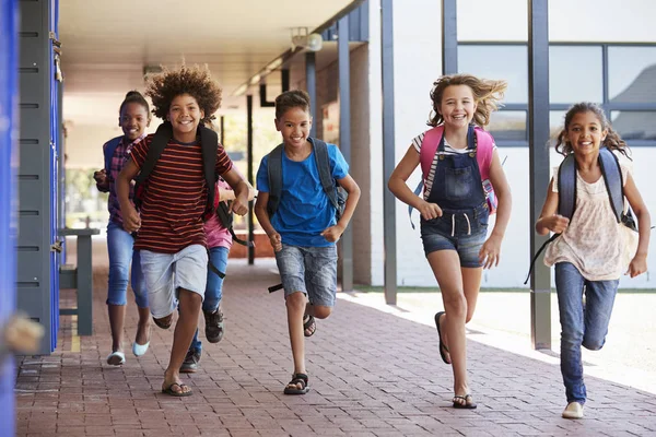 Дети, бегающие в коридоре начальной школы — стоковое фото