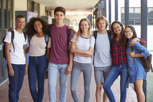 Одноклассники, стоящие в коридоре средней школы — стоковое фото