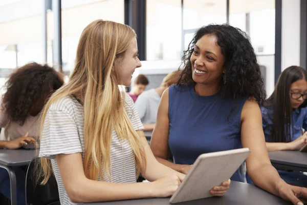 Teacher helping schoolgirl with tablet — Stock Photo, Image