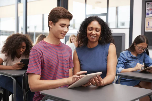 Teacher helping schoolboy with tablet — Stock Photo, Image