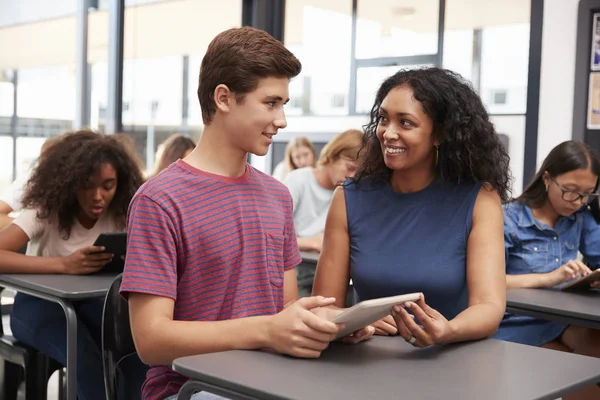 Insegnante aiutare scolaro con tablet — Foto Stock