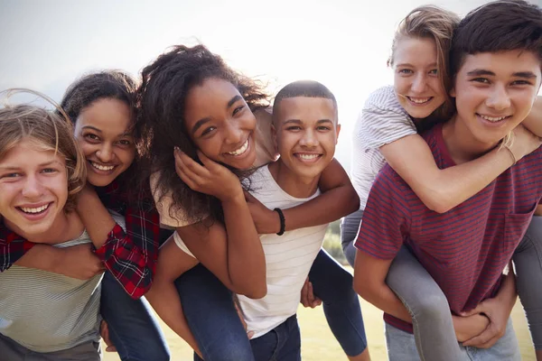 Teenage friends piggybacking outdoors — Stock Photo, Image