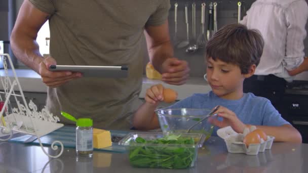 Família na cozinha seguinte receita — Vídeo de Stock