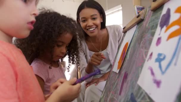 Учитель помогает детям в художественном классе — стоковое видео
