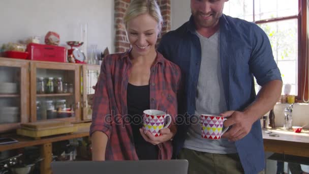 Paar met laptop in de keuken — Stockvideo