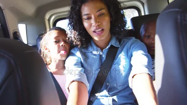 Мама фотографируется с детьми в машине — стоковое видео