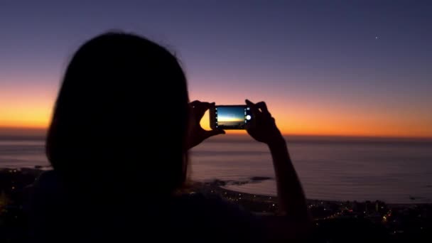 Woman taking photos, silhouette at sunset — Stock Video