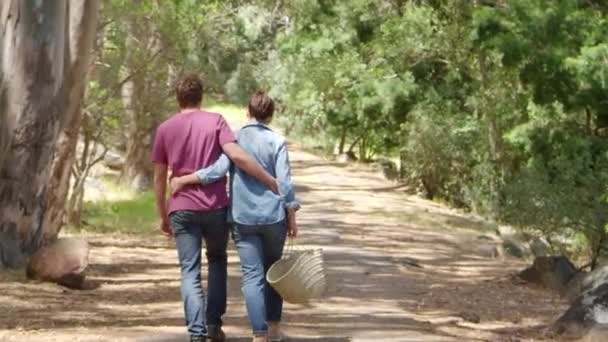 Caminhadas de casal ao longo do caminho da floresta — Vídeo de Stock