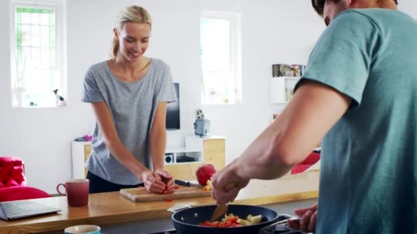 Молода пара готує їжу разом — стокове відео