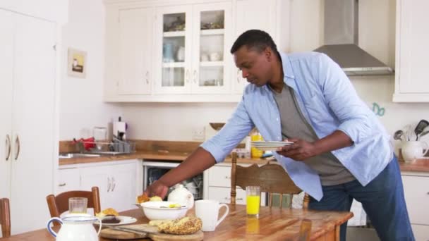 Hombre limpiando mesa de desayuno — Vídeo de stock