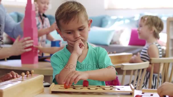 Ученик работает с деревянными головоломками — стоковое видео