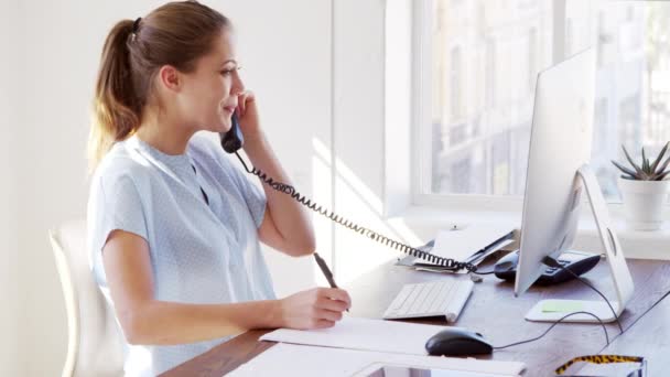 Женщина заканчивает телефонный звонок в офисе — стоковое видео