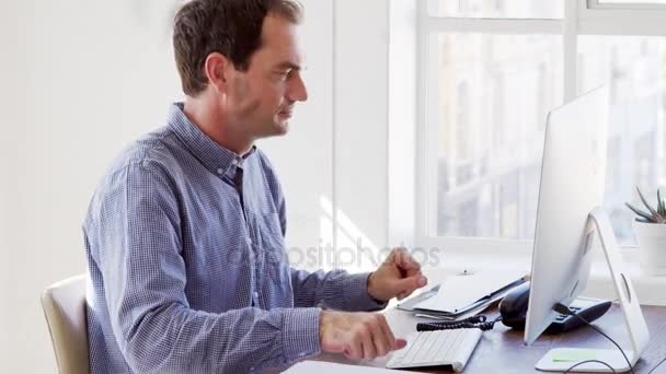 Hombre usando el teléfono y la computadora en la oficina — Vídeo de stock