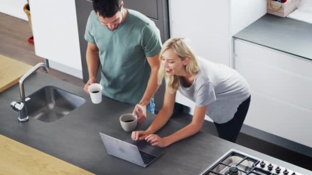 Pareja mirando portátil en la cocina moderna — Vídeos de Stock