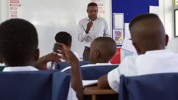 Crianças levantando as mãos na lição da escola — Vídeo de Stock