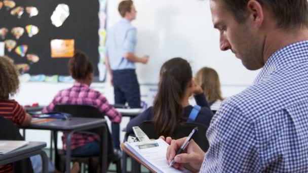 Trainee lärare att göra anteckningar i skolan lektion — Stockvideo