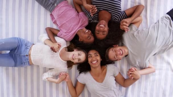Друзі підлітки лежать на ліжку разом — стокове відео