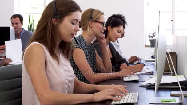 Жінки з гарнітурами в офісі — стокове відео