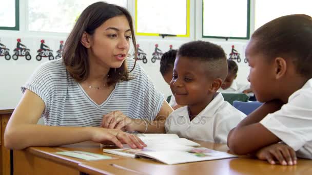 Profesor ayudando a los niños de la escuela en clase — Vídeos de Stock